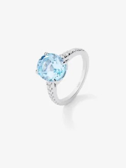 Anillo de oro amarillo de 18K con topacio azul sky en talla oval de 3,8 cts y diamantes en talla brillante