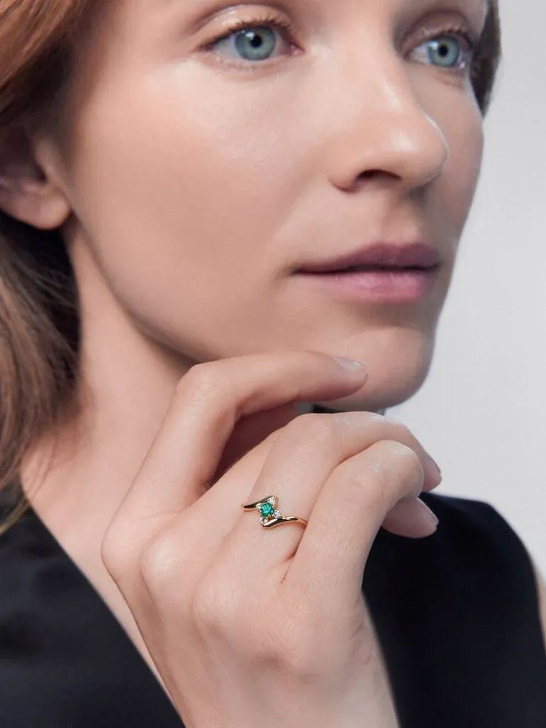 Anillo de oro amarillo de 18K con esmeralda verde en talla brillante de 0,088 cts y 4 diamantes en talla brillante con un total de 0,08 cts