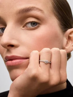 Anillo de oro blanco de 18K con diamante central en talla brillante de 0,15 cts y orla y brazo de 28 diamantes en talla brillante con un total de 0,3 cts