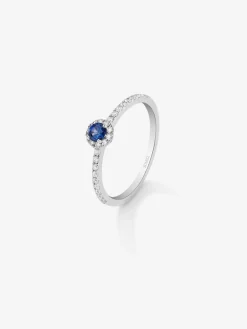 Anillo de oro blanco de 18K con zafiro azul en talla brillante de 0,26 cts y orla y brazo de 26 diamantes en talla brillante con un total de 0,26 cts
