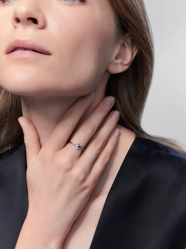 Anillo de oro blanco de 18K con zafiro azul en talla brillante de 0,15 y 4 diamantes en talla brillante con un total de 0,08 cts
