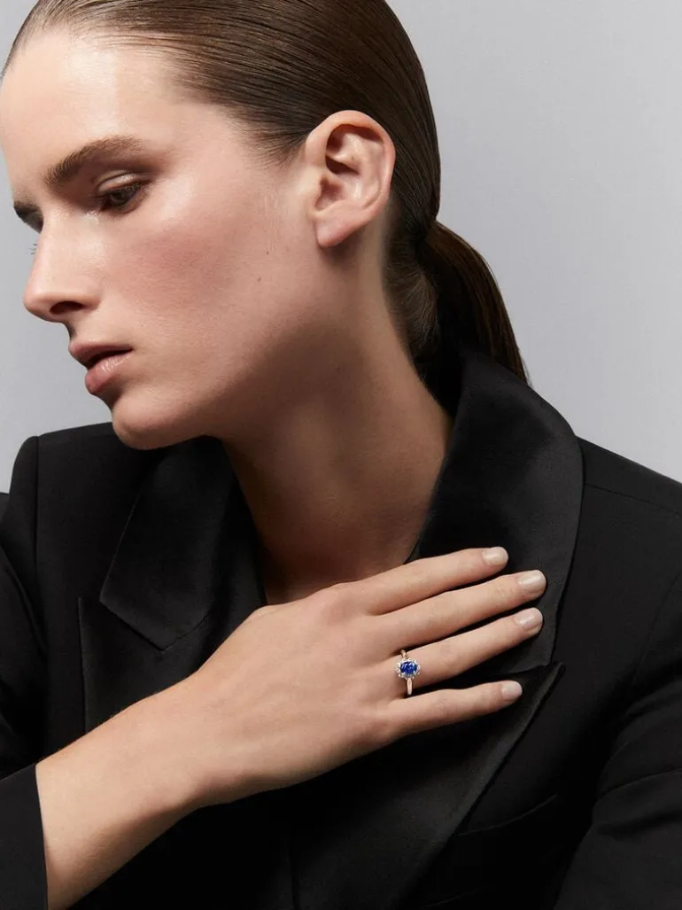 Anillo de oro blanco de 18K con zafiro azul en talla oval de 1,5 cts y 12 diamantes en talla brillante con un total de 0,53 cts