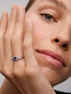 Anillo de oro blanco de 18K con zafiro azul vivid en talla oval de 1,292 cts y 32 diamantes en talla brillante con un total de 0,6 cts