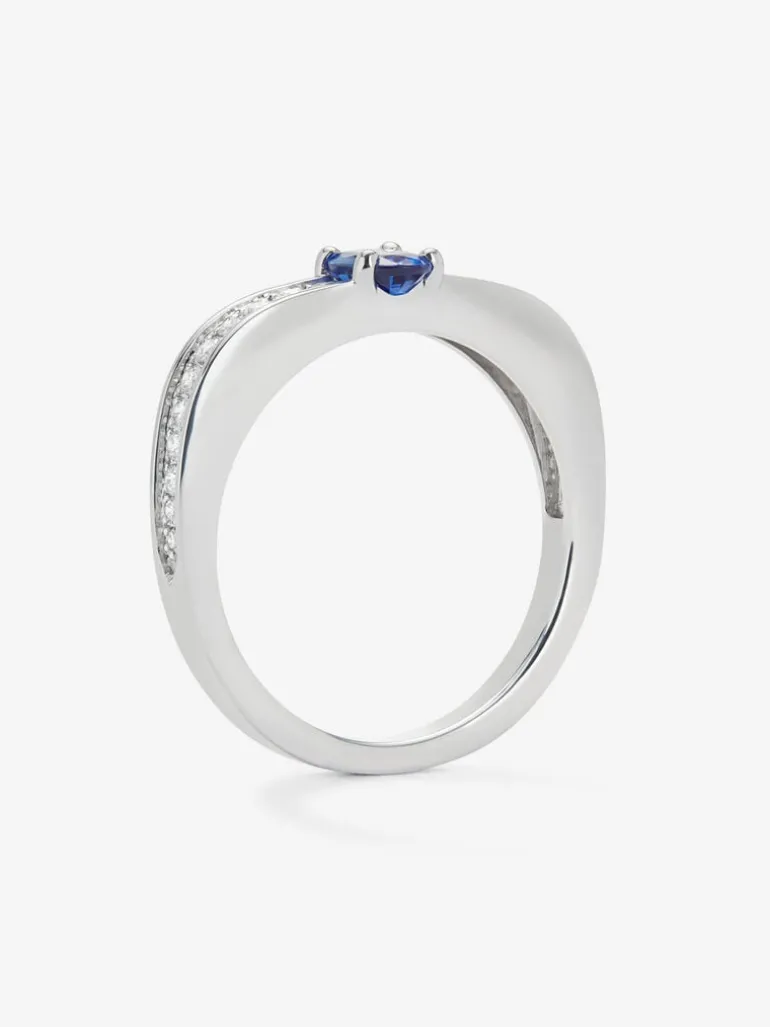 Anillo de oro blanco de 18K con zafiro azul en talla oval de 0,47 cts y 22 diamantes en talla brillante con un total de 0,16 cts