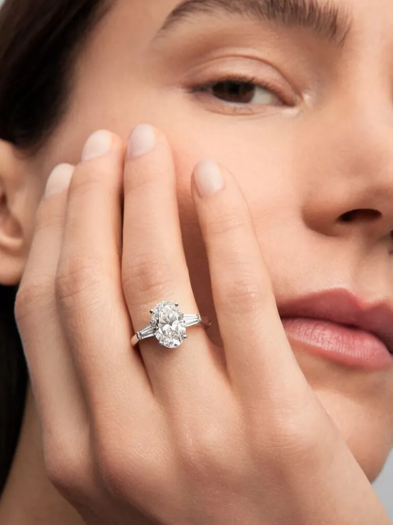 Anillo de oro blanco de 18K con diamante en talla oval de 3,01 cts y 2 diamantes en talla trapecio con un total de 0,49 cts