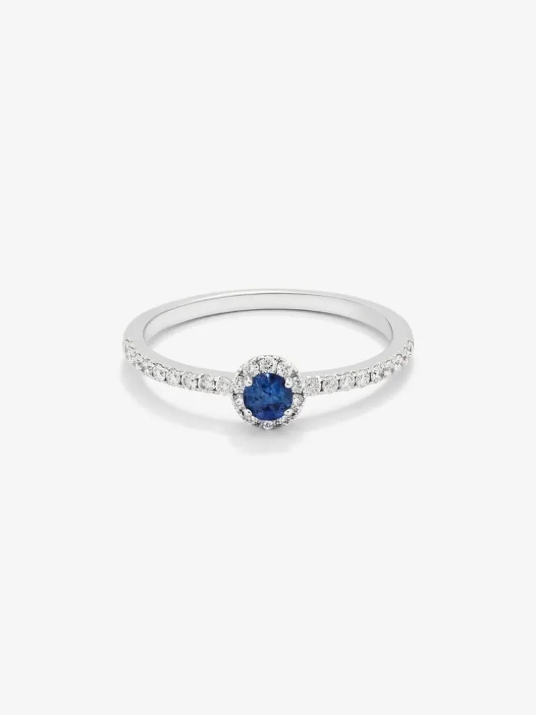 Anillo de oro blanco de 18K con zafiro azul en talla brillante de 0,15 cts y orla y brazo de 28 diamantes en talla brillante con un total de 0,2 cts