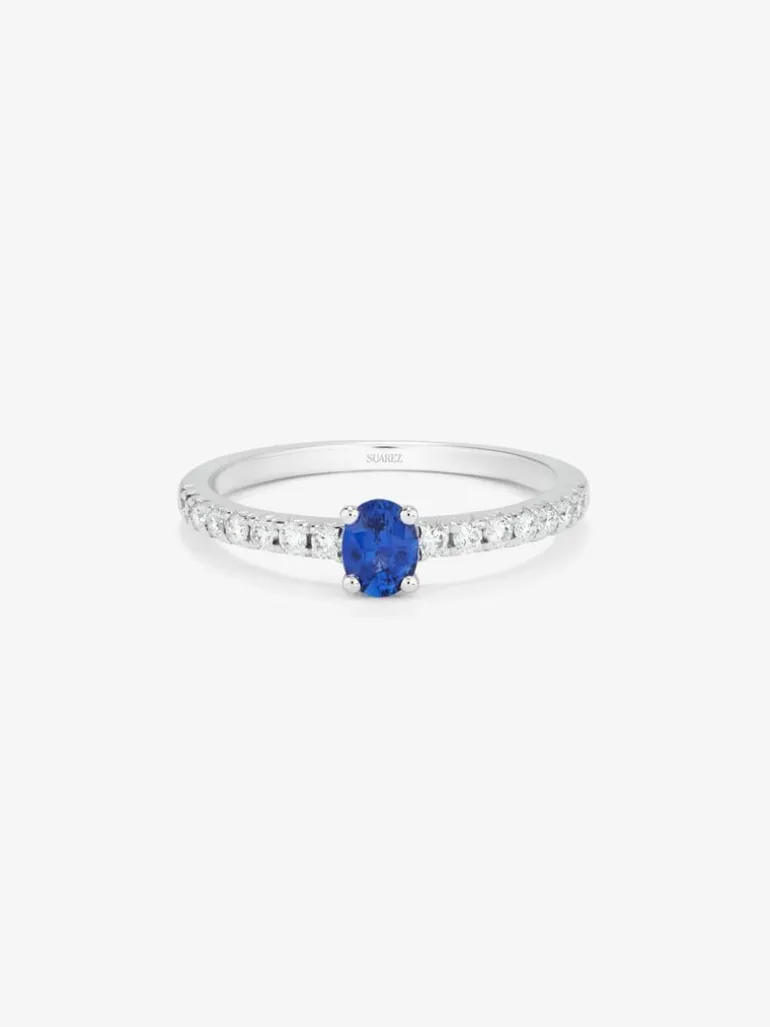 Anillo de oro blanco de 18K con zafiro azul en talla oval de 0,21 cts y 16 diamantes en talla brillante con un total de 0,2 cts