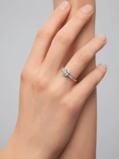 Anillo de oro blanco de 18K con diamante central en talla brillante de 0,4 cts y orla con 2 diamantes en talla baguette con un total de 0,14 cts y 30 en talla brillante con un total de 0,19 cts
