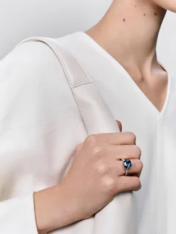 Anillo de oro blanco de 18K con topacio azul london en talla cushion de 3,8 cts y 12 diamantes en talla brillante con un total de 0,29 cts