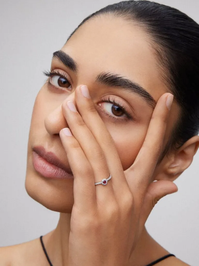 Anillo de oro blanco de 18K con rubí rojo en talla brillante de 0,1 cts y orla y brazo de 28 diamantes en talla brillante con un total de 0,2 cts