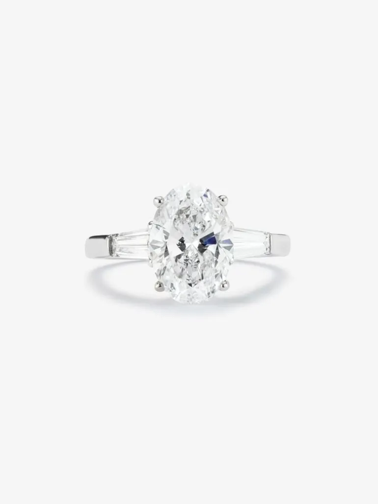 Anillo de oro blanco de 18K con diamante en talla oval de 3,01 cts y 2 diamantes en talla trapecio con un total de 0,49 cts