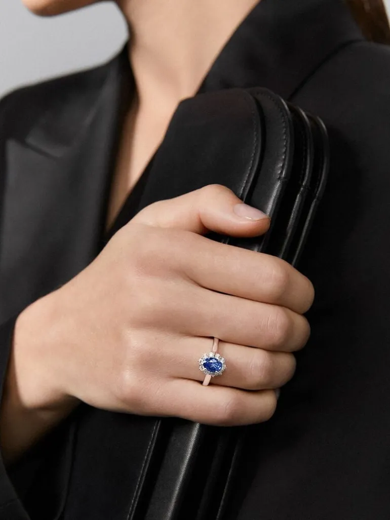 Anillo de oro blanco de 18K con zafiro azul en talla oval de 1,5 cts y 12 diamantes en talla brillante con un total de 0,53 cts