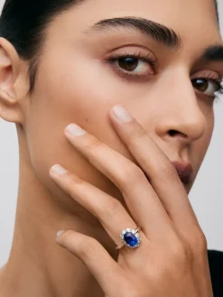 Anillo de oro blanco de 18K con zafiro azul royal en talla oval de 2,33 cts y orla de 12 diamantes en talla brillante con un total de 0,52 cts