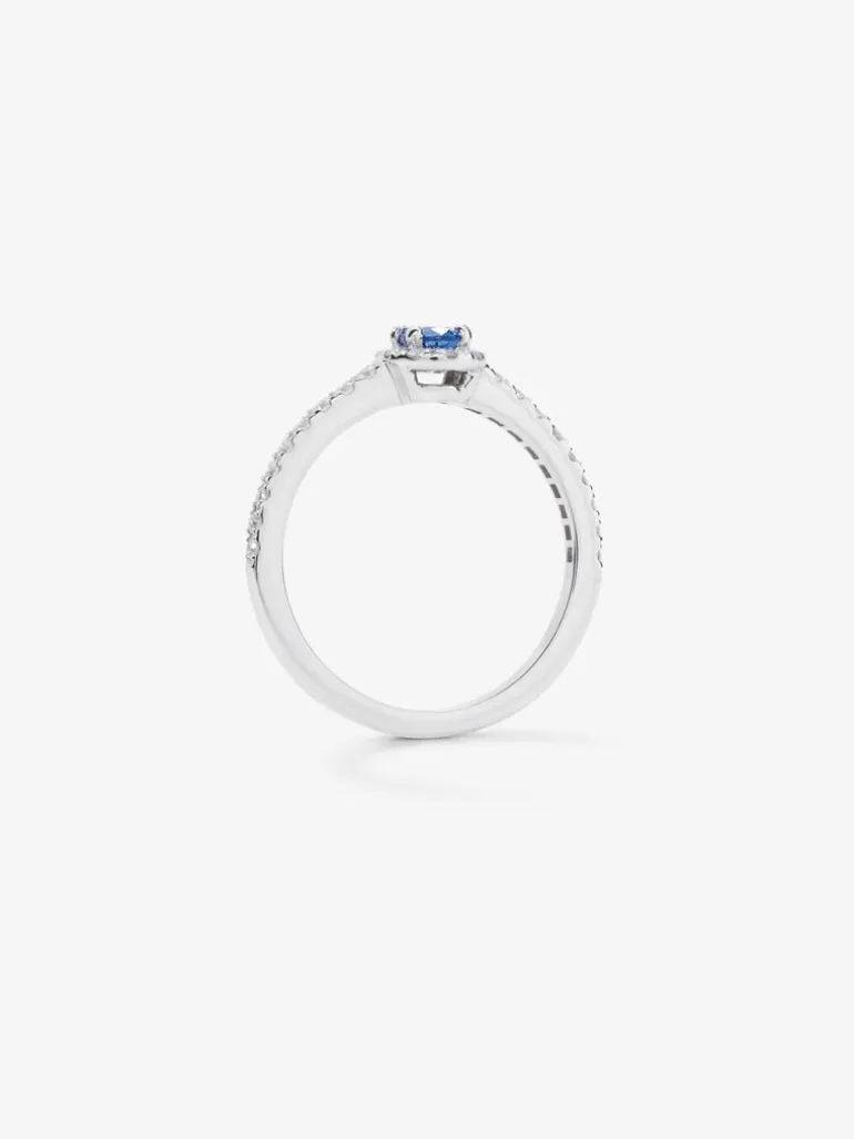 Anillo de oro blanco de 18K con zafiro azul en talla oval de 0,31 cts y 26 diamantes en talla brillante con un total de 0,216cts