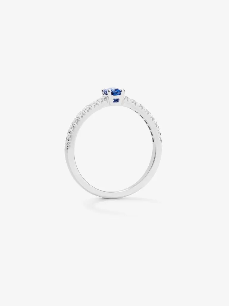 Anillo de oro blanco de 18K con zafiro azul en talla oval de 0,3 cts y brazo de 16 diamantes en talla brillante con un total de 0,2 cts