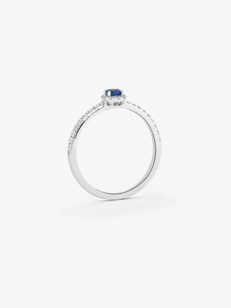 Anillo de oro blanco de 18K con zafiro azul en talla brillante de 0,15 cts y orla y brazo de 28 diamantes en talla brillante con un total de 0,2 cts