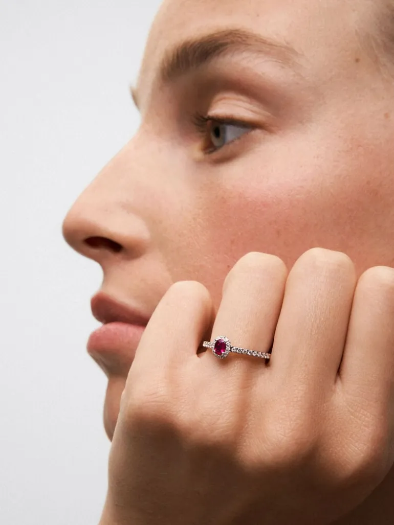 Anillo solitario de oro blanco de 18K con rubí rojo en talla oval de 0,24 cts y diamantes en talla brillante con un total de 0,24 cts