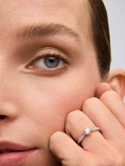 Anillo solitario de oro blanco de 18K con diamante central en talla brillante de 0,70 cts y diamantes en talla brillante con un total de 0,30 cts
