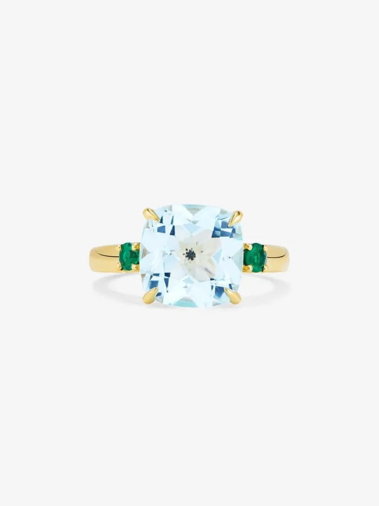 Anillo tresillo de oro amarillo de 18K con topacio azul sky en talla cushion de 4,88 cts y 2 esmeraldas verdes en talla brillante