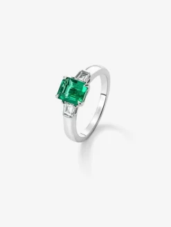 Anillo tresillo de oro blanco de 18K con esmeralda verde vivid en talla esmeralda de 1,64 cts y 2 diamantes blancos en talla fantasía con un total de 0,4 cts