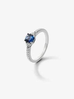 Anillo tresillo de oro blanco de 18K con zafiro azul cornflower en talla cushion de 1,09 cts y 16 diamantes en talla brillante con un total de 0,28 cts