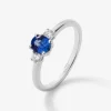 Anillo tresillo de oro blanco de 18K con zafiro azul en talla oval de 0,69 cts y 2 diamantes en talla brillante con un total de 0,16 cts