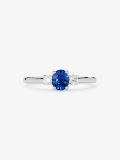 Anillo tresillo de oro blanco de 18K con zafiro azul en talla oval de 0,69 cts y 2 diamantes en talla brillante con un total de 0,16 cts