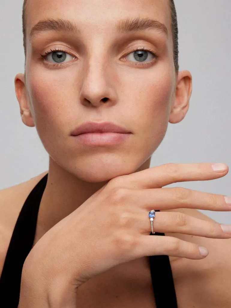 Anillo tresillo de oro blanco de 18K con zafiro azul en talla octogonal de 0,7 cts y 2 diamantes en talla brillante con un total de 0,26 cts