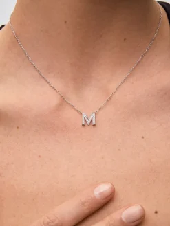 Colgante de oro blanco de 18K con letra M en pavé de 28 diamantes en talla brillante con un total de 0,13 cts
