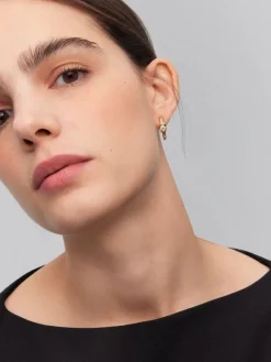 Pendientes de aro de oro amarillo de 18K con diamantes blancos en talla brillante de 0,11 cts y forma de nudo