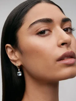Pendientes de oro amarillo de 18K con topacios azul sky en talla cushion y 2 diamantes en talla brillante con un total de 0,21 cts