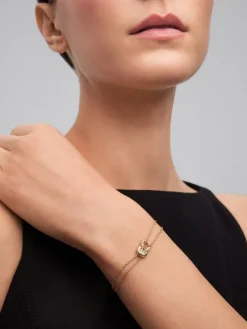 Pulsera de oro amarillo de 18K con 17 diamantes en talla brillante con un total de 0,15 cts y forma de nudo
