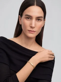 Pulsera r&iacute;gida de oro amarillo de 18K con 69 diamantes en talla brillante con un total de 0,42 cts