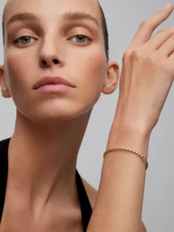 Pulsera r&iacute;gida de oro amarillo de 18K con 21 diamantes en talla brillante con un total de 0,29 cts