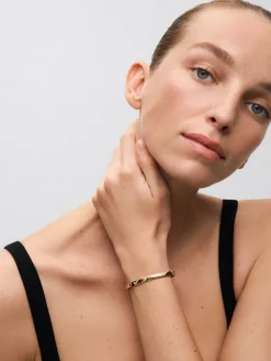 Pulsera r&iacute;gida de oro amarillo de 18K con diamantes blancos en talla brillante de 0,13 cts