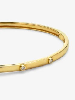 Pulsera r&iacute;gida de oro amarillo de 18K con 3 diamantes en talla brillante con un total de 0,07 cts