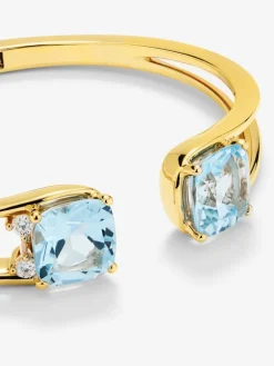 Pulsera r&iacute;gida de oro amarillo de 18K con 2 topacios azul sky en talla cushion con un total de 0,12 cts