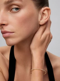 Pulsera r&iacute;gida de oro amarillo de 18K con 21 diamantes en talla brillante con un total de 0,29 cts