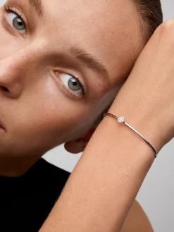 Pulsera r&iacute;gida de oro blanco de 18K con 11 diamantes en talla brillante con un total de 0,2 cts