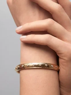 Pulsera r&iacute;gida de oro amarillo de 18K con 11 diamantes en talla brillante con un total de 0,36 cts